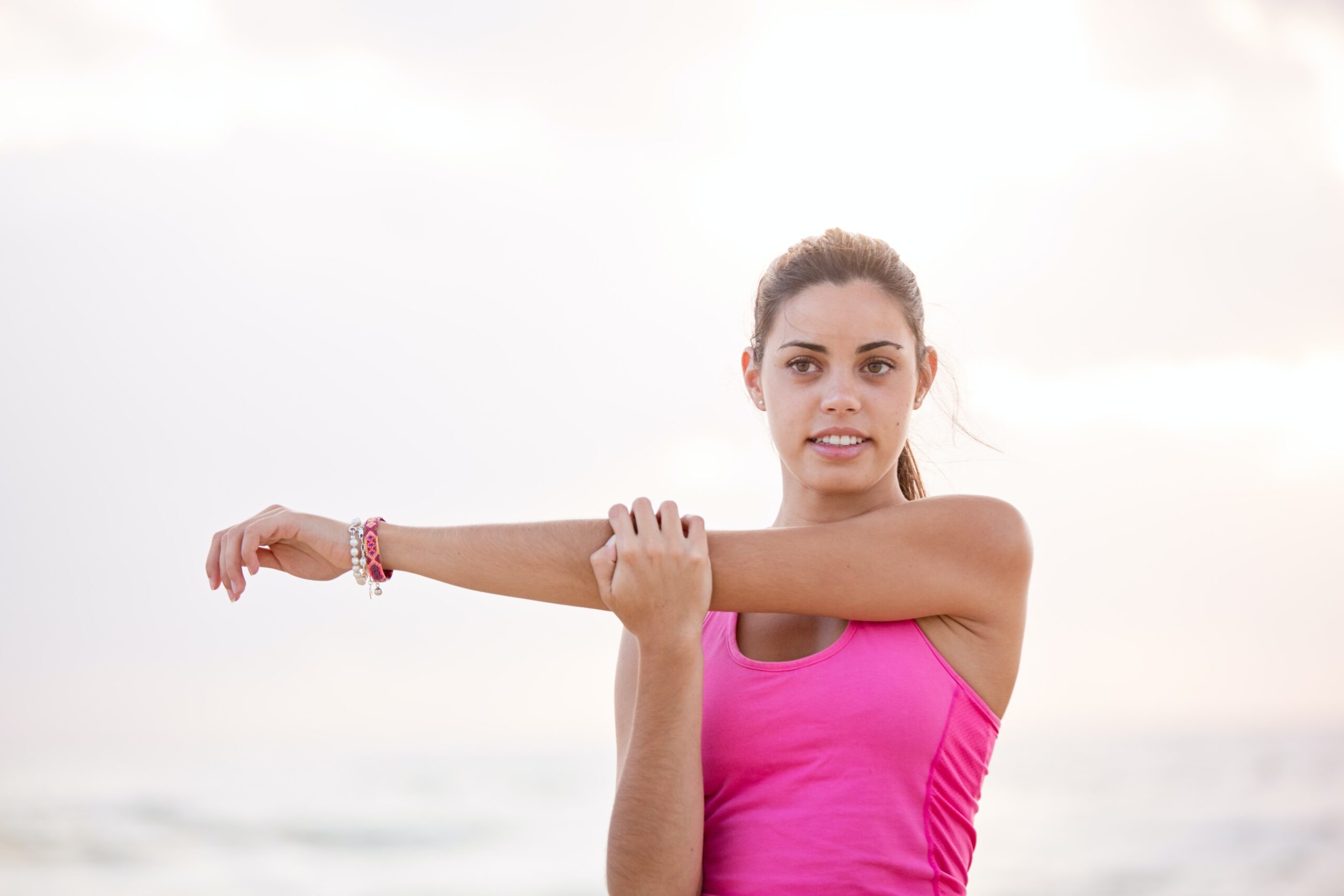 photography of woman in pink tank top stretching arm 634030 scaled